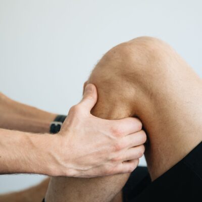 Behandler arbejder med massage omkring knæet