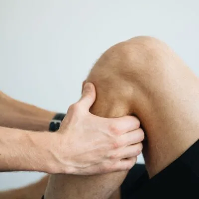 Behandler arbejder med massage omkring knæet