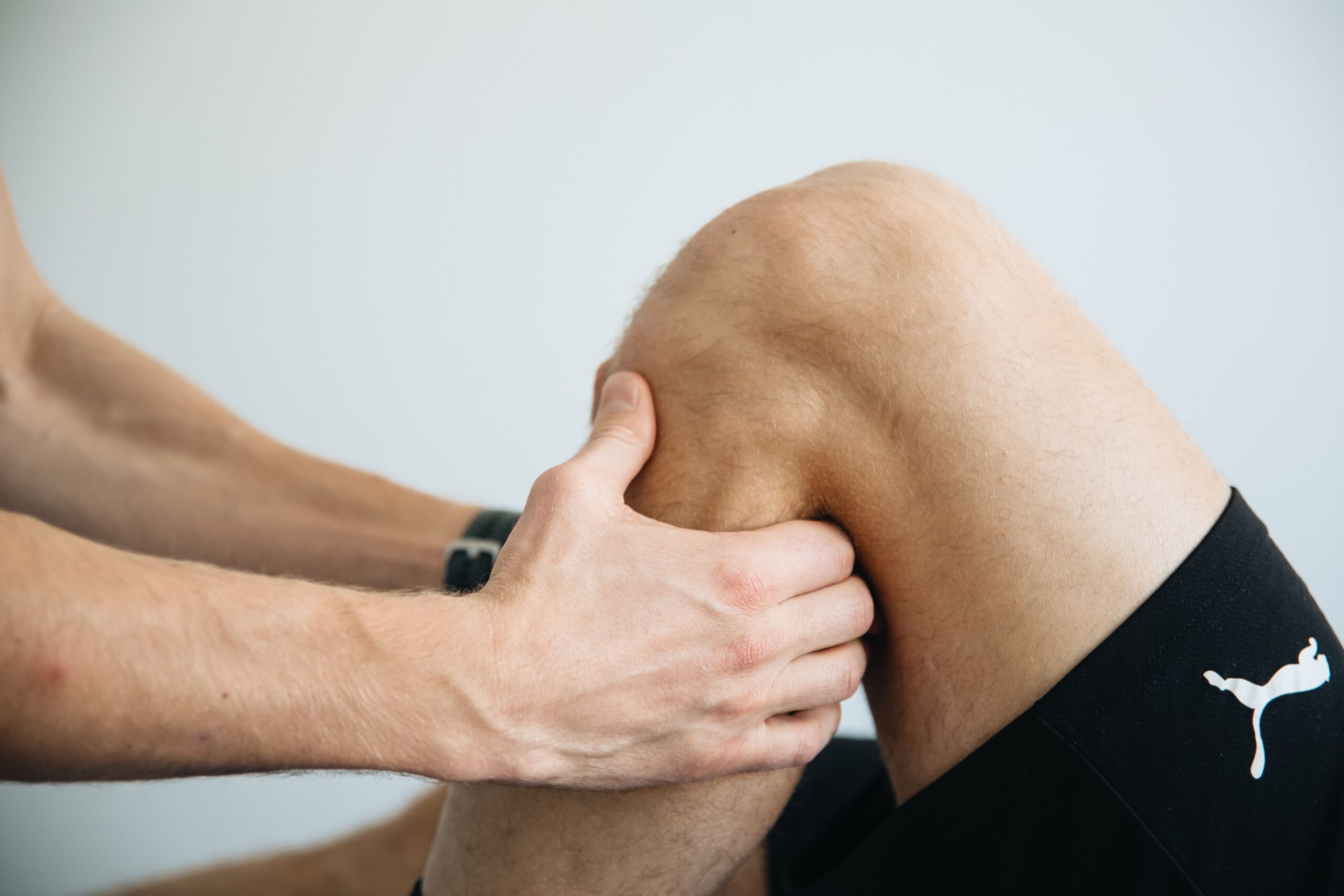 Behandler arbejder med massage omkring knæet